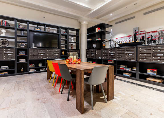 a dining room with a table and chairs and a tv in a room with shelves