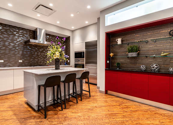 a kitchen with a large island and red cabinets