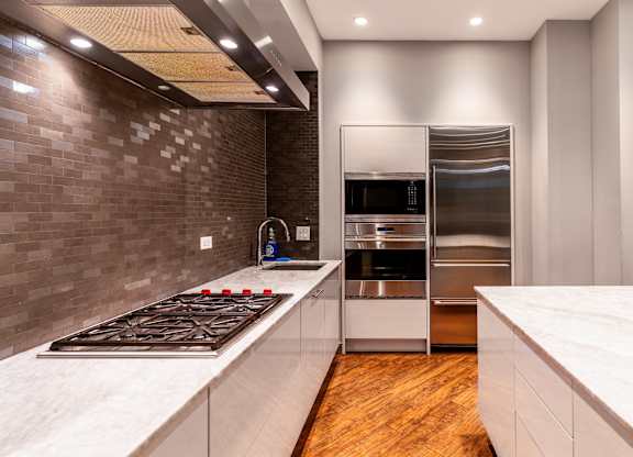 a kitchen with stainless steel appliances and white countertops