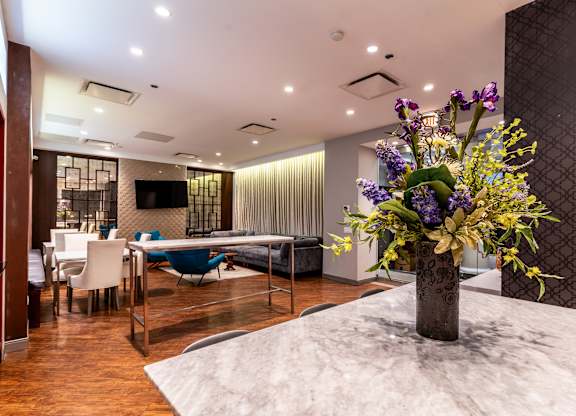 a living room with a table with a vase of flowers on it