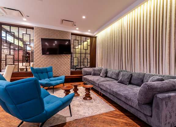 a living room with blue chairs and a gray couch
