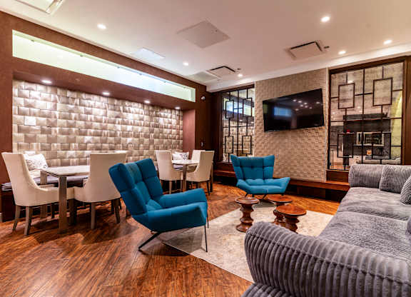 a living room with a couch and chairs and a table and a television