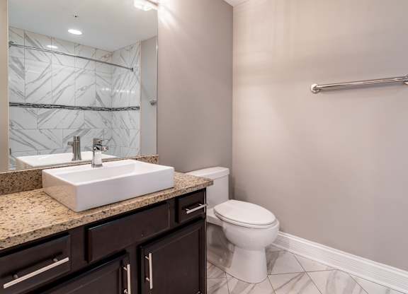 a bathroom with a toilet and a sink and a mirror