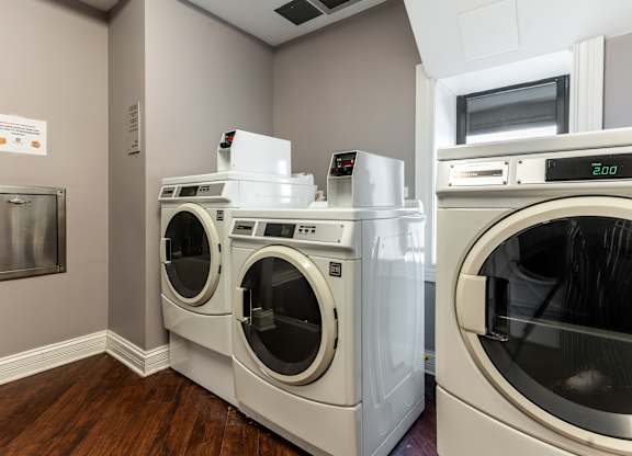 a laundry room with two washers and two washing machines