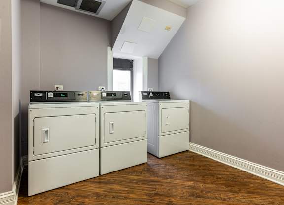 an empty laundry room with white appliances and a window