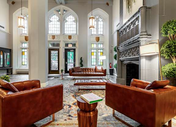 a large lobby with leather furniture and a fireplace at Park Heights by the Lake Apartments, Illinois, 60649