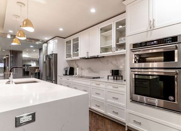 a white kitchen with stainless steel appliances and white counter tops at Park Heights by the Lake Apartments, Chicago, 60649