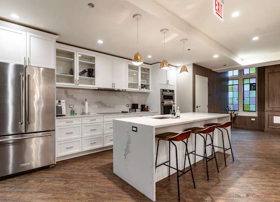 a large kitchen with white cabinets and a white counter top and a stainless steel refrigerator at Park Heights by the Lake Apartments, Chicago, Illinois