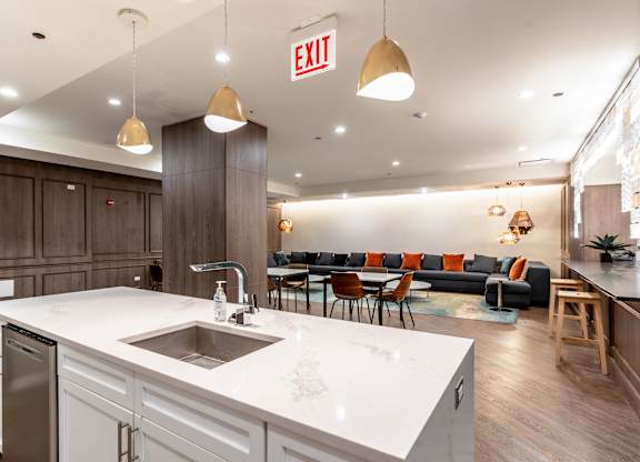 a kitchen with a sink and a counter top and a living room with couches at Park Heights by the Lake Apartments, Chicago, Illinois