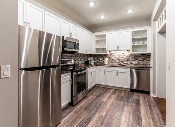 a kitchen with stainless steel appliances and white cabinets at Park Heights by the Lake Apartments, Illinois