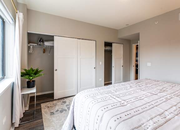 a bedroom with a large bed and a closet with white doors at Park Heights by the Lake Apartments, Chicago