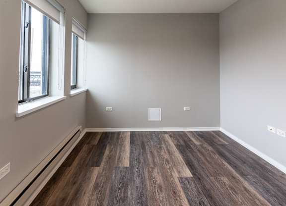 an empty room with wood flooring and a window at Park Heights by the Lake Apartments, Chicago, Illinois