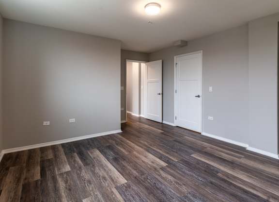 a living room with wood flooring and white walls and doors at Park Heights by the Lake Apartments, Illinois, 60649