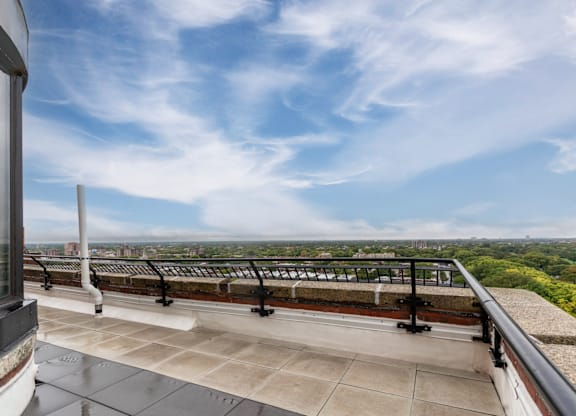 a balcony with a view of a city and a blue sky at Park Heights by the Lake Apartments, Chicago, 60649