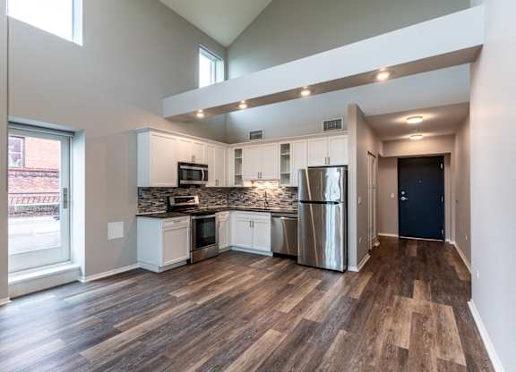 an open kitchen with stainless steel appliances and a large window at Park Heights by the Lake Apartments, Chicago, IL