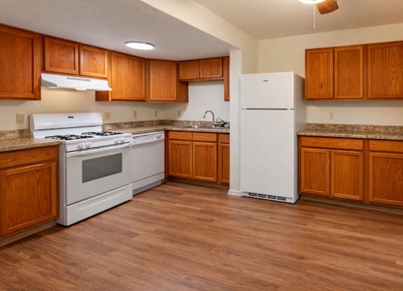A kitchen with wooden cabinets and a white refrigerator.