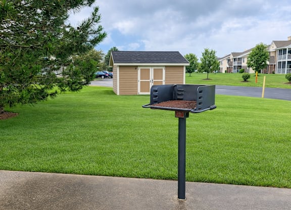 A mailbox sits on a pole in front of a green lawn.
