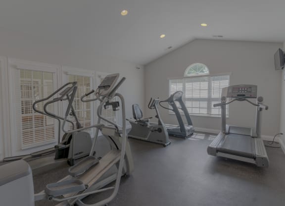 a gym with treadmills and other exercise equipment in a building