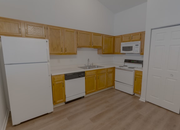 an empty kitchen with white appliances and wooden cabinets