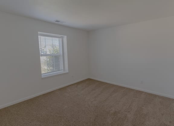 an empty room with carpet and a window