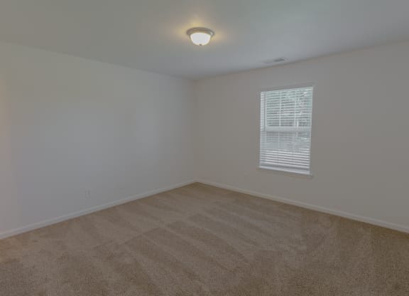an empty room with carpet and a window