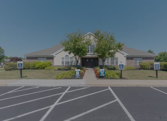 the front of a house with signs in the parking lot