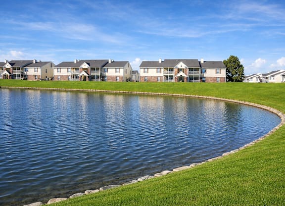 A row of houses with a pond in front.