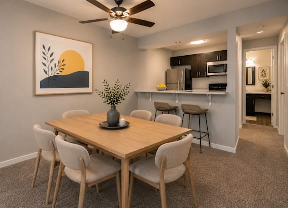 A dining room with a wooden table and chairs.