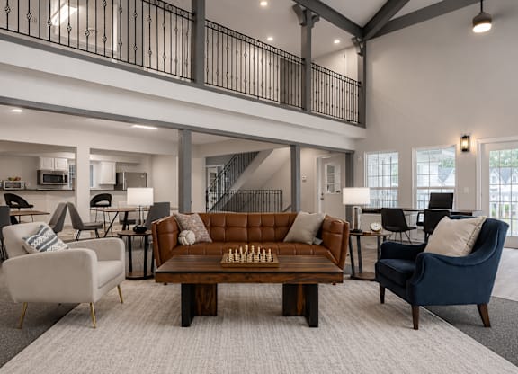 A living room with a brown couch and a white chair.