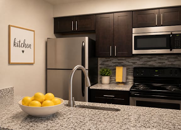 A kitchen with a bowl of lemons on the counter.