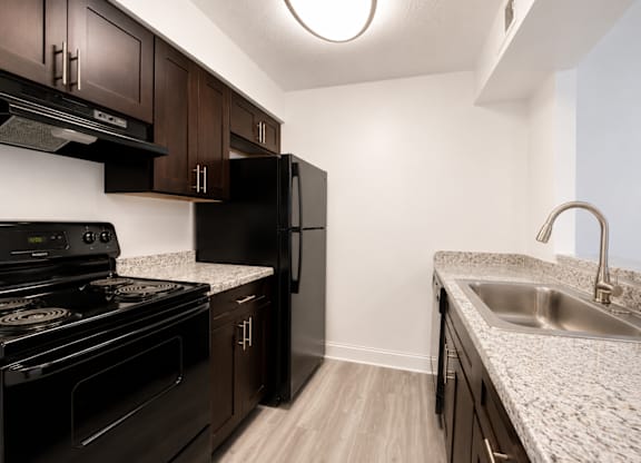 A kitchen with black appliances and wooden cabinets.