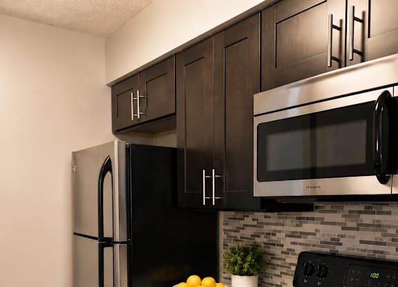 A black stove top oven with a yellow towel hanging on it.