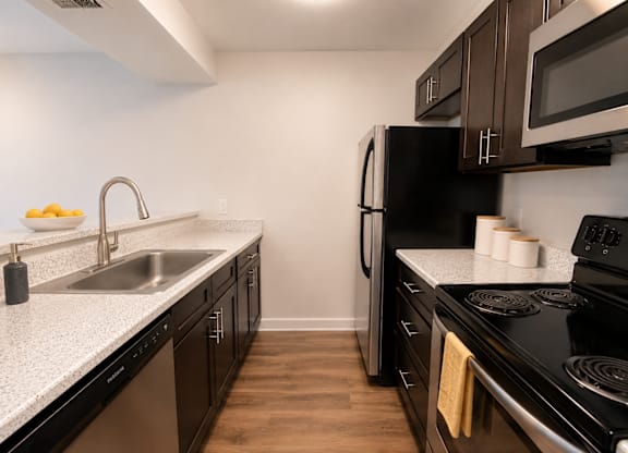 A kitchen with black appliances and wooden cabinets.