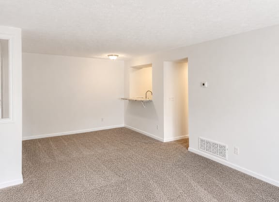 A room with a carpet floor and a white wall.