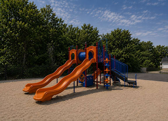 A playground with a slide and a blue railing.