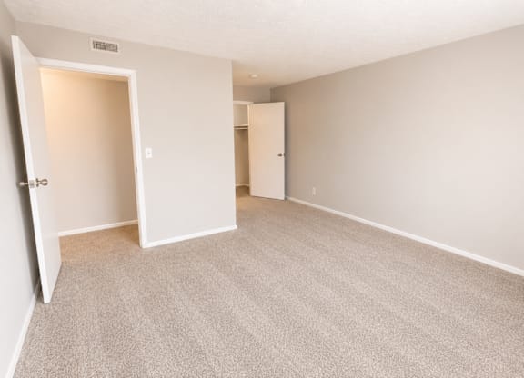 A room with carpeted floor and two doors.