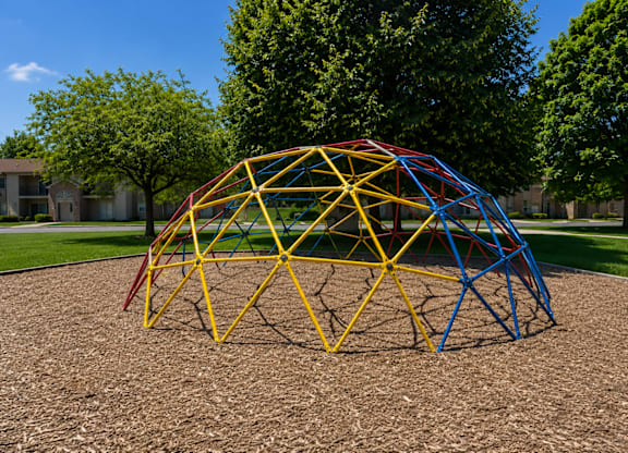 A playground with a yellow and blue structure.