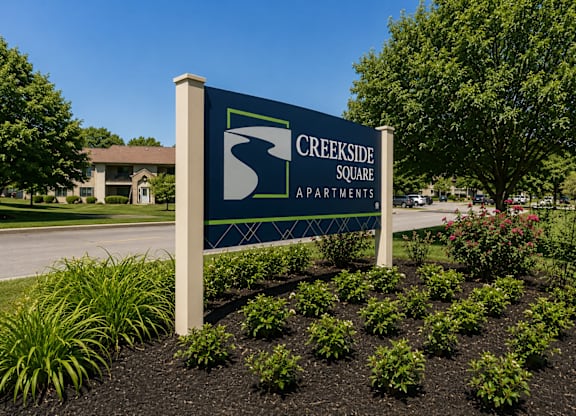 A sign for Creekside Square Apartments is shown in front of a building.