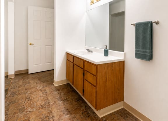 A bathroom with a wooden vanity and a white door.