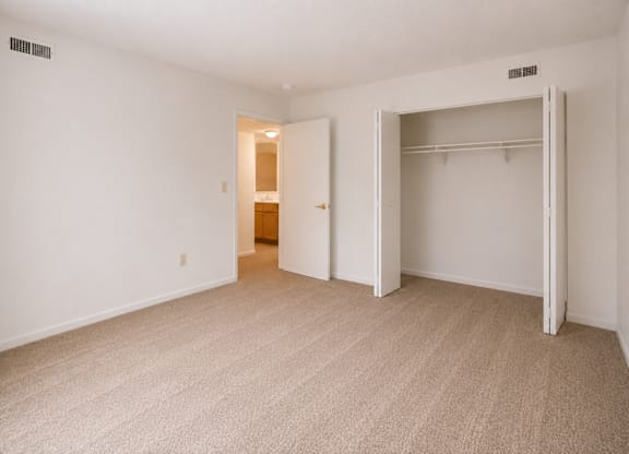 A room with a carpeted floor and two open doors.