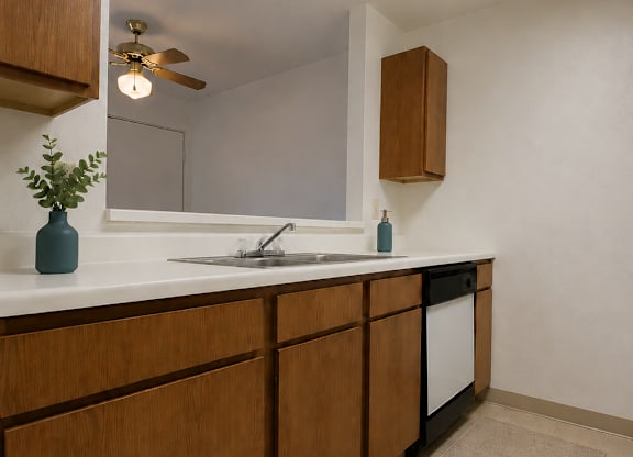 A kitchen with wooden cabinets and a white countertop.