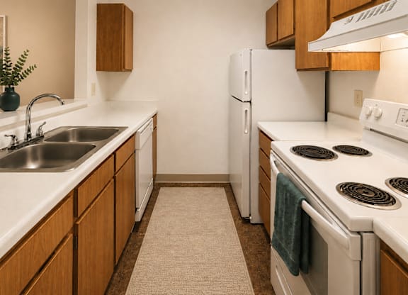 A kitchen with white appliances and wooden cabinets.