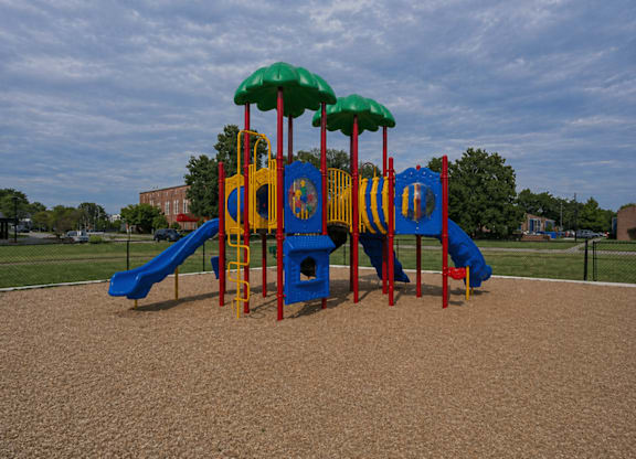 A playground with a blue slide and a yellow and red play structure.