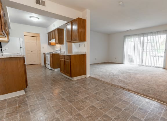 the kitchen and living room of an empty house with a large window
