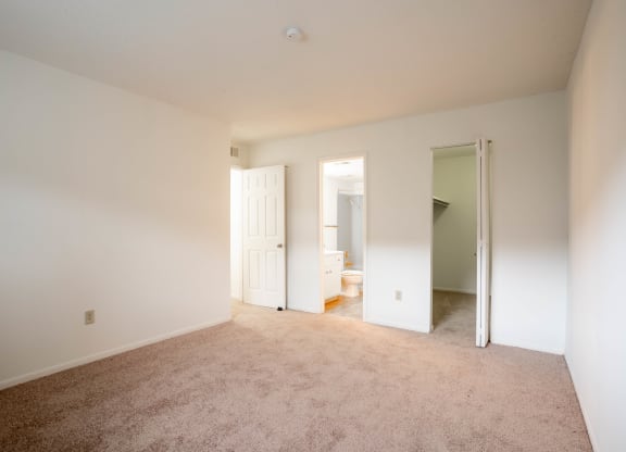 an empty room with a carpeted floor and white walls