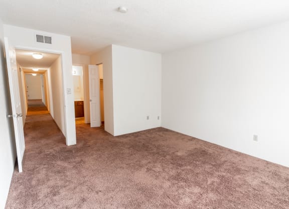 an empty living room with white walls and carpet