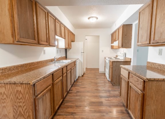 a kitchen with wooden cabinets and counters and a white refrigerator