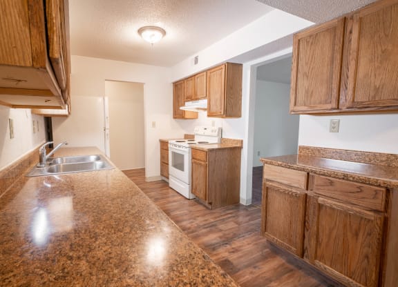 a kitchen with wooden cabinets and a counter top and a sink