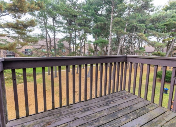 a deck with a view of a yard and trees