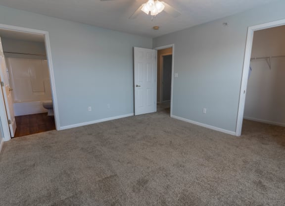 an empty living room with a carpeted floor and blue walls